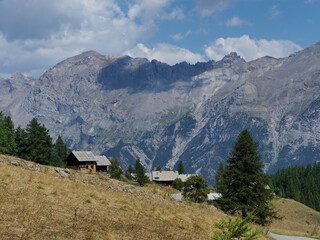 Fototapeta na wymiar hameau en montagne dans les alpes, au milieu des alpages, sous un ciel bleu