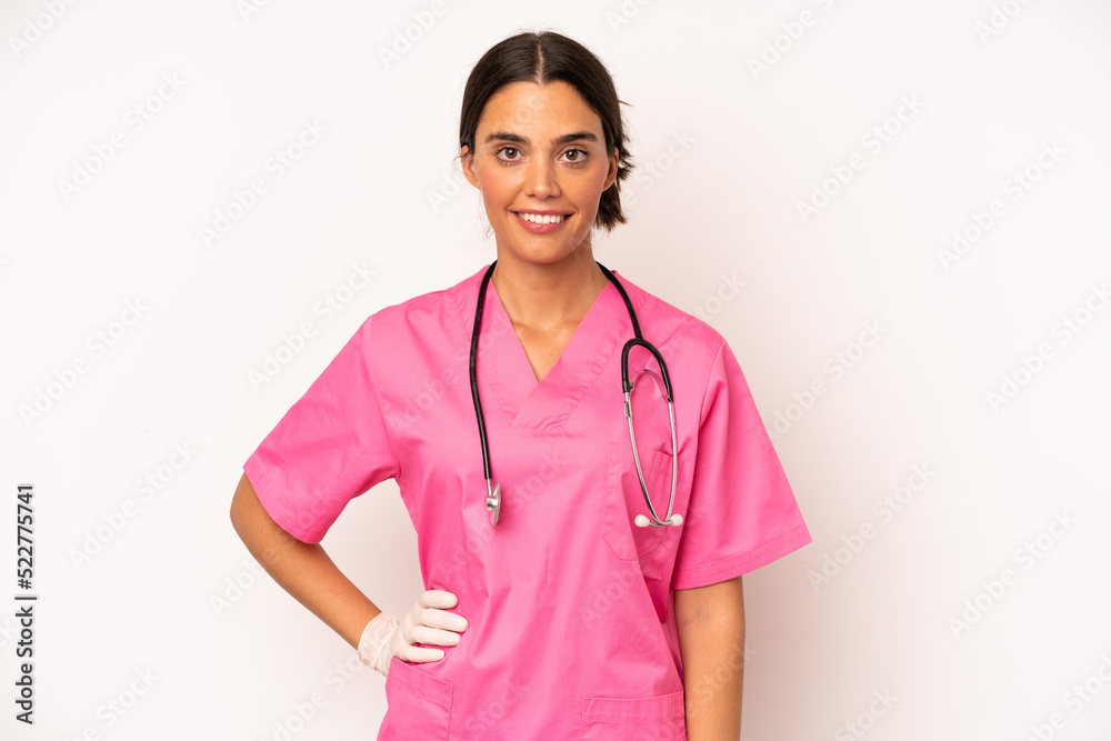 Wall mural pretty hispanic woman smiling happily with a hand on hip and confident. veterinarian concept