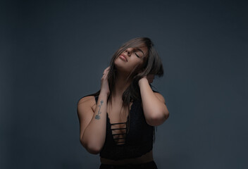 Being seductive and posing in studio while touching herself on the neck