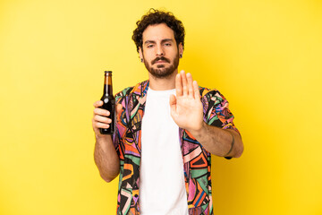 crazy bearded man looking serious showing open palm making stop gesture. beer and vacations concept