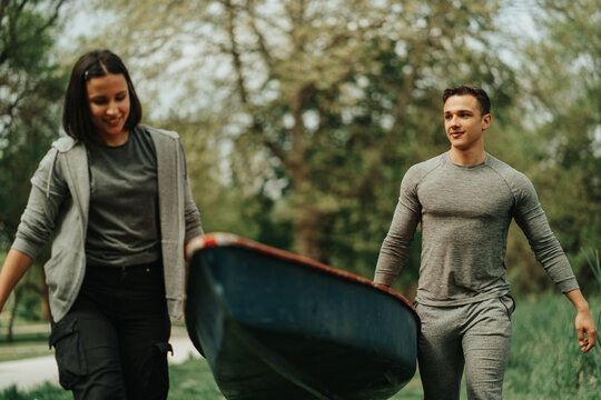 Couple Carrying A Kayak