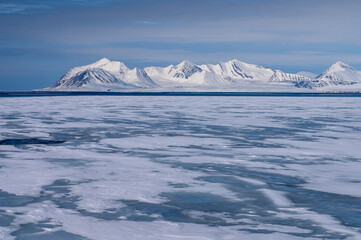 Views of the coast of Svalbard with mountains, ice and ocean in the sunshine