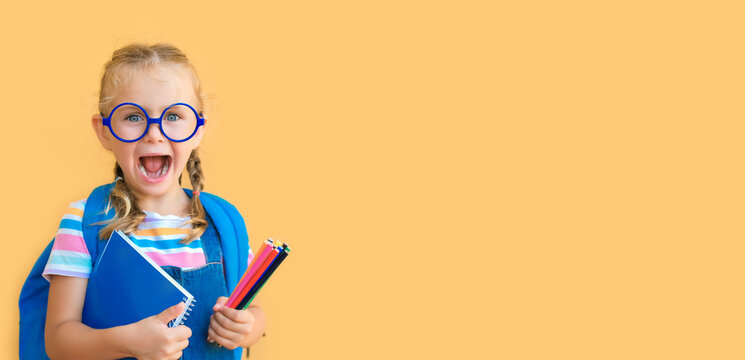 Banner. emotional excited surprise face school child in glasses in school uniform holds colored pencils, notebook, backpack open mouth isolated on yellow background. Back to school sale