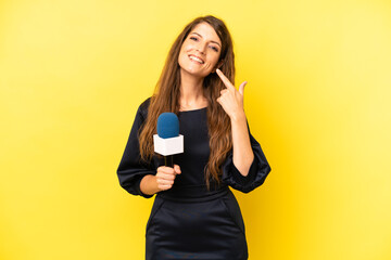 pretty caucasian woman smiling confidently pointing to own broad smile. tv presenter concept