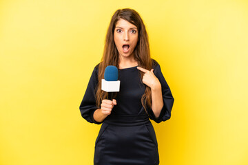 pretty caucasian woman looking shocked and surprised with mouth wide open, pointing to self. tv...