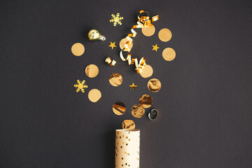 Happy New Year! Modern creative firework flat lay. Golden confetti popping from festive wrapping...