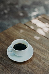 Cup of black coffee on a table in a street cafe.