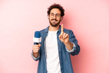 crazy bearded man smiling and looking friendly, showing number one. presenter with a microphone...