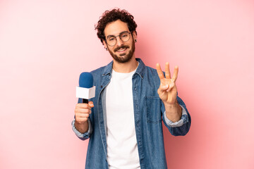 crazy bearded man smiling and looking friendly, showing number three. presenter with a microphone...
