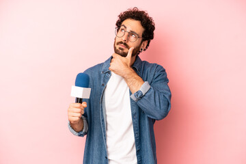 crazy bearded man thinking, feeling doubtful and confused. presenter with a microphone concept