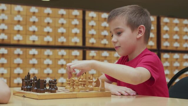 4K. Children play chess in the library