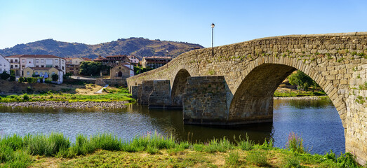Fototapeta na wymiar Medieval stone bridge over the River Tormes as it passes through the old village of Barco de Avila, Spain.