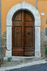 Wooden door with an arched marble frame, Tuscany, Italy