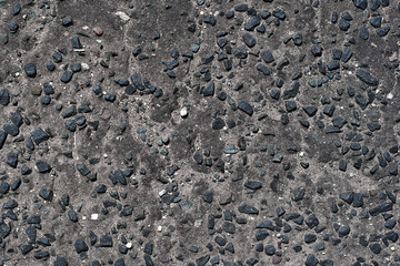 Perfect black asphalt interspersed with large gravel close-up. Texture of black asphalt in England