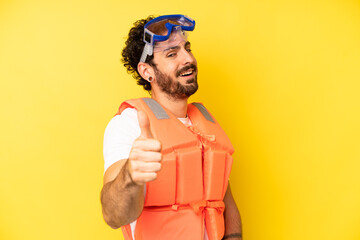 Fototapeta crazy bearded man feeling proud,smiling positively with thumbs up. life jacket concept obraz