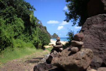Rock cairn or stack at trail to Cacimba do Padre beach, with Two Brothers Hills at background.