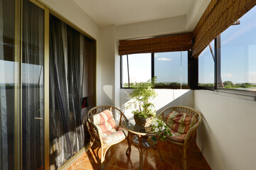 Enclosed glazed terrace with bamboo and hemp furniture and perimeter views