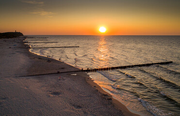 breakwaters by the sea at sunset