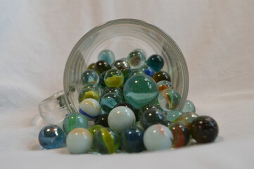 Marbles flowing from a glass cup