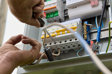 Fastening circuit breakers to DIN rail of consumer unit of electrical panel. Mounting fuse box for...