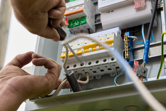 Fastening circuit breakers to DIN rail of consumer unit of electrical panel. Mounting fuse box for distribution board.
