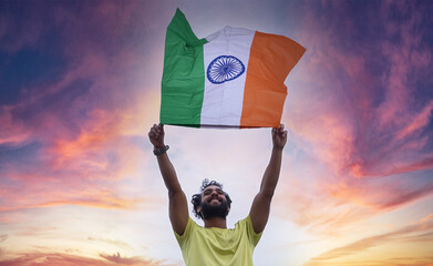 Young man waving indian national flag over beautiful sky background