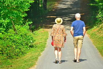 Happy elderly couple during a hiking tour  in summer sunny day.