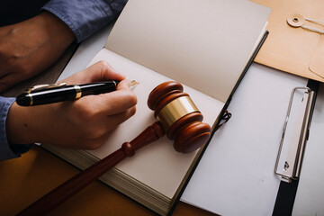 Male lawyer working with contract papers and wooden gavel on tabel in courtroom. justice and law ,attorney, court judge, concept.