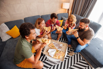 Friends eating pizza while spending leisure time together at home