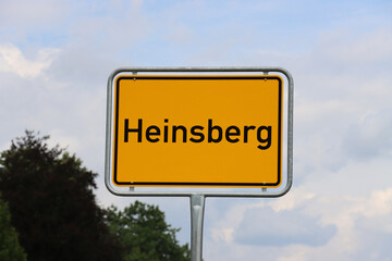 Ortsschild Heinsberg: Orangenes Schild am Ortseingang der Stadt Heinsberg 2022