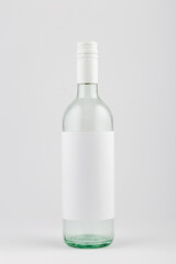 Transparent white wine bottle with blank white label on white background, mock up.
