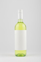 White wine bottle with blank white label on white background, mock up.