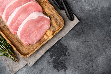 Sliced raw pork meat, on gray stone table background, top view flat lay, with copy space for text