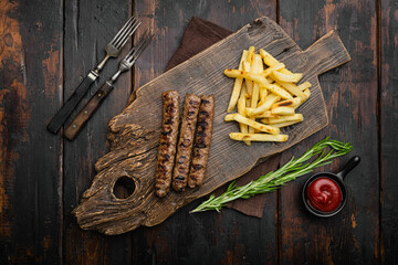 Grilled Lula kebab with french fries, on old dark  wooden table background, top view flat lay