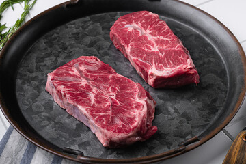 Fresh beef meat Top Blade steaks, on white ceramic squared tile table background