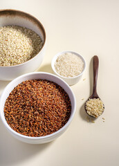 Uncooked rice assortment in bowl on white background. Top view.