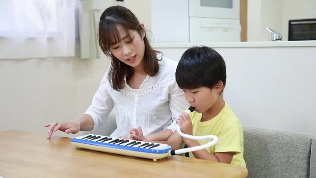 鍵盤ハーモニカの練習をする親子