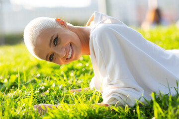 Portrait of young smiling beautiful girl on green grass meadow at summer park