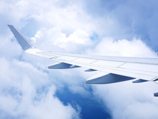 Fototapeta na wymiar 飛行機の機内から見た雲と飛行機の翼（羽）