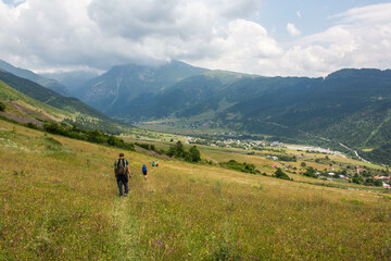 Fototapeta na wymiar People walking into the town of Tsaldashi, during the trek from the town of Mestia to Ushguli, in Geogia.