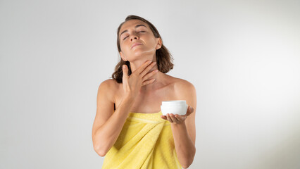 A woman applies cream to the neck - home care