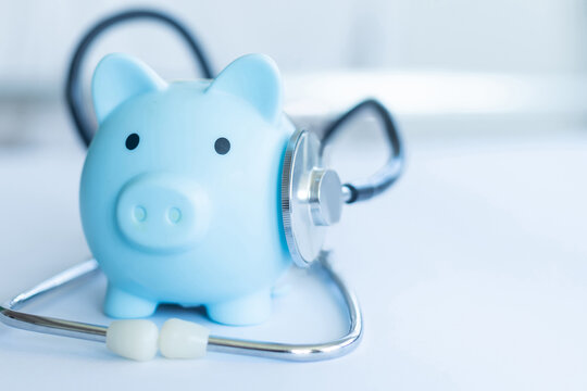 Piggy bank with stethoscope isolated on light blue background with copy space. Health care financial checkup or saving for medical insurance costs concept
