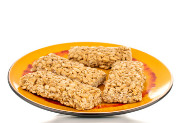 Several sweet roasted sweets from sunflower seeds and honey on a ceramic saucer, macro, isolated on a white background.