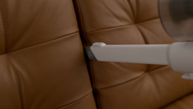 Close up footage of cleaning sofa with vacuum cleaner 