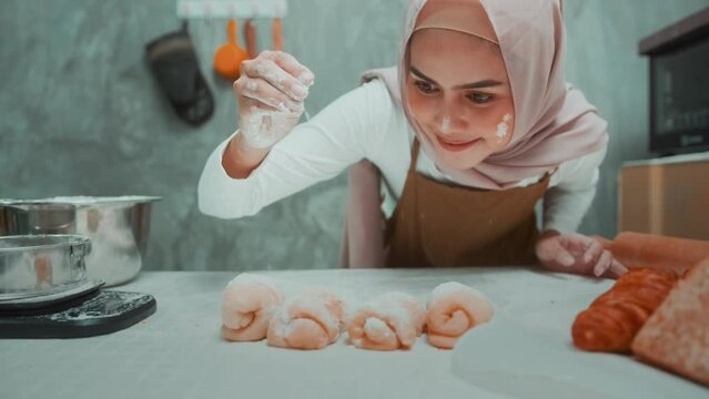 Young beautiful muslim woman is baking in her kitchen , bakery and coffee shop business