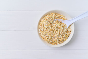 bowl of granola with a spoon. white wooden background. top view. copy space.