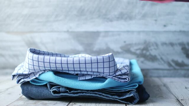 men hand putting shirts on table 