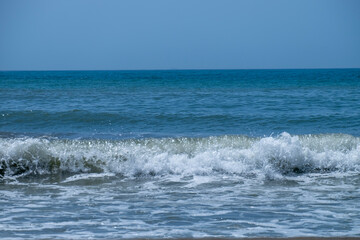 Ocean waves crashing on sandy beach. Sea waves breaking on Maditerranean's shore.