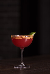 Red cocktail and lime garnish