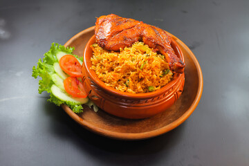 Chicken matka biryani with salad served in a matka isolated on dark background side view of indian spicy food - obrazy, fototapety, plakaty